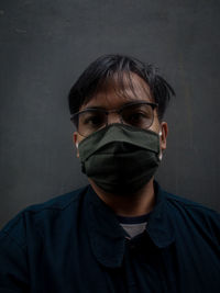 Portrait of young man standing against wall