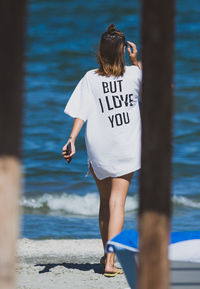 Rear view of woman standing at beach