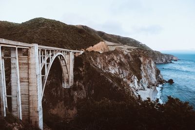 Arch bridge over sea against sky