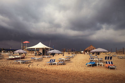 Chairs on beach against sky