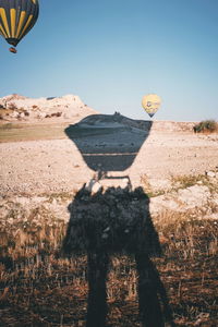 View of hot air balloons on field against sky