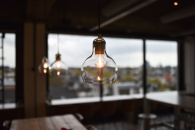 Illuminated pendant light hanging in restaurant