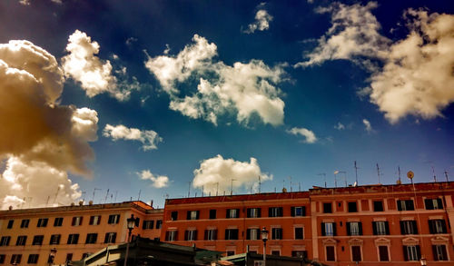 Low angle view of buildings against cloudy sky