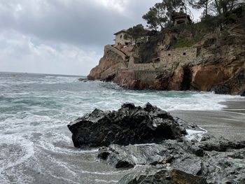 Rock formation on beach against sky