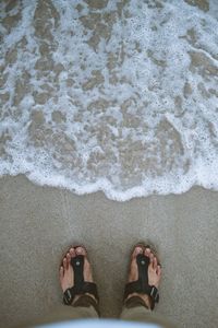 Low section of man standing on beach