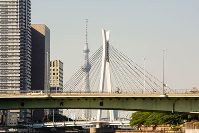 Low angle view of bridge and buildings against clear sky