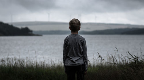 Rear view of boy standing on field