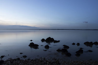 Scenic view of lake against sky at dusk