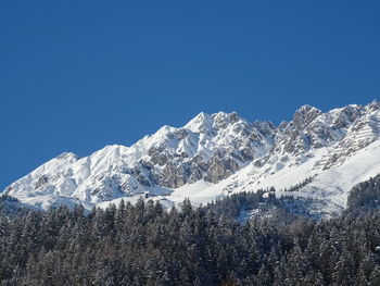 Scenic view of snowcapped mountains against clear blue sky