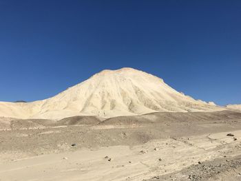 Scenic view of desert against clear blue sky