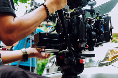 Cropped hand of man holding camera