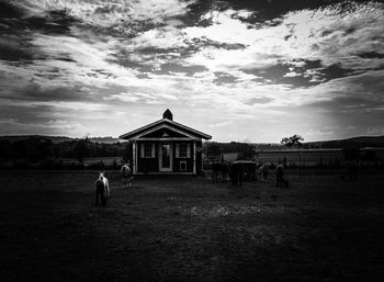 People on field against cloudy sky