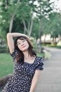 Young woman standing against trees