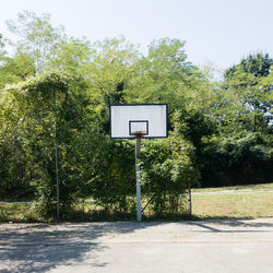 Basketball hoop against trees and sky