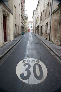 Road sign in city against sky