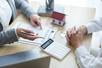 Midsection of estate agent and client having discussion