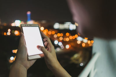 Midsection of man using mobile phone at night
