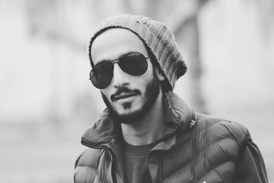 Portrait of handsome young man wearing sunglasses and knit hat