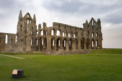Low angle view of old ruins against cloudy sky