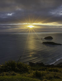 Scenic view of sea against sky during sunrise with sunrays or starbust