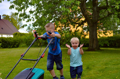 Full length portrait of father and son playing on grass