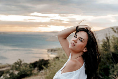 Portrait of beautiful young girl in white summer dress. confident, pretty, hair, hairstyle.