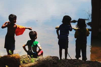 Rear view of children at riverbank