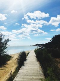Footpath by sea against sky