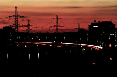 Silhouette bridge against sky at night