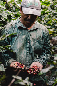 Midsection of man holding apple growing in field