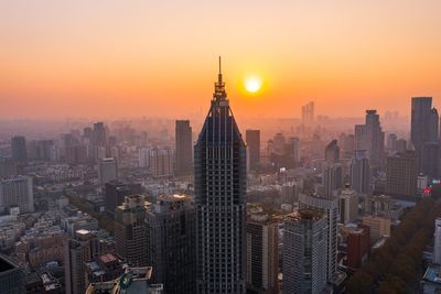 Aerial view of buildings in city during sunset