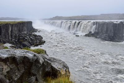 Scenic view of waterfall against clear sky