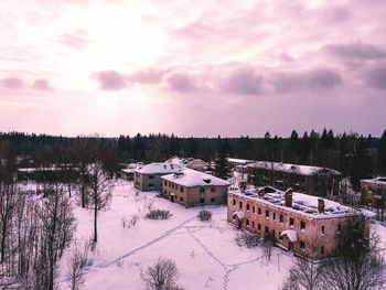 Built structure on snow covered field against sky