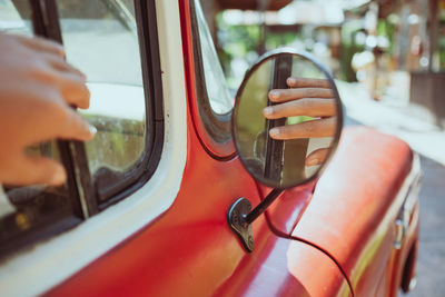 Reflection of hand in side-view mirror of car