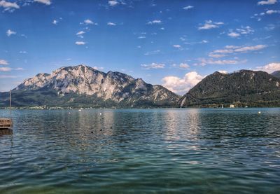 Scenic view of lake by mountains against sky