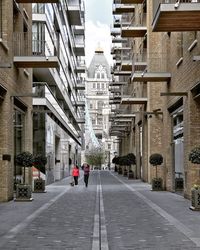 People walking in city against sky