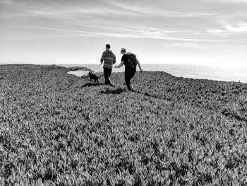 Friends standing on field against sky