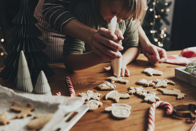 Christmas and new year food preparation. gingerbread cooking, decorating cookies with icing, mastic