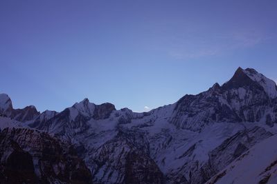 Scenic view of snowcapped mountains against blue sky