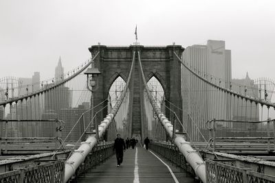 People on brooklyn bridge in city