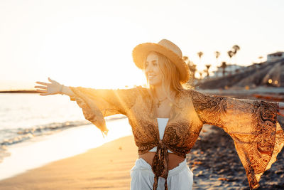 Portrait of young woman standing at beach