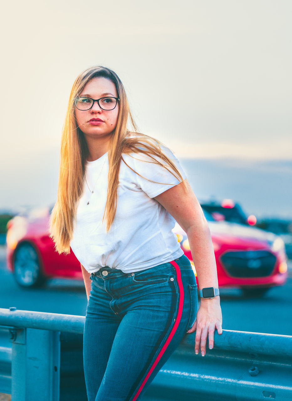 glasses, hair, young adult, one person, three quarter length, long hair, transportation, young women, real people, mode of transportation, lifestyles, blond hair, car, hairstyle, motor vehicle, leisure activity, land vehicle, fashion, front view, beautiful woman