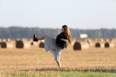 Beautiful woman dancing on field