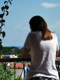 Rear view of woman standing against sky