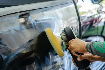 Cropped hands cleaning car