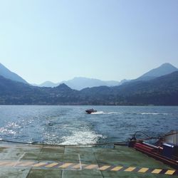 Boats in sea with mountains in background