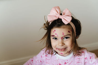 Portrait of cute girl with red spots painted on face