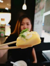 Portrait of woman holding ice cream in restaurant