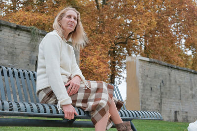 Woman sitting on bench in park