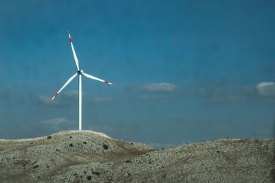 Wind turbines on land against sky